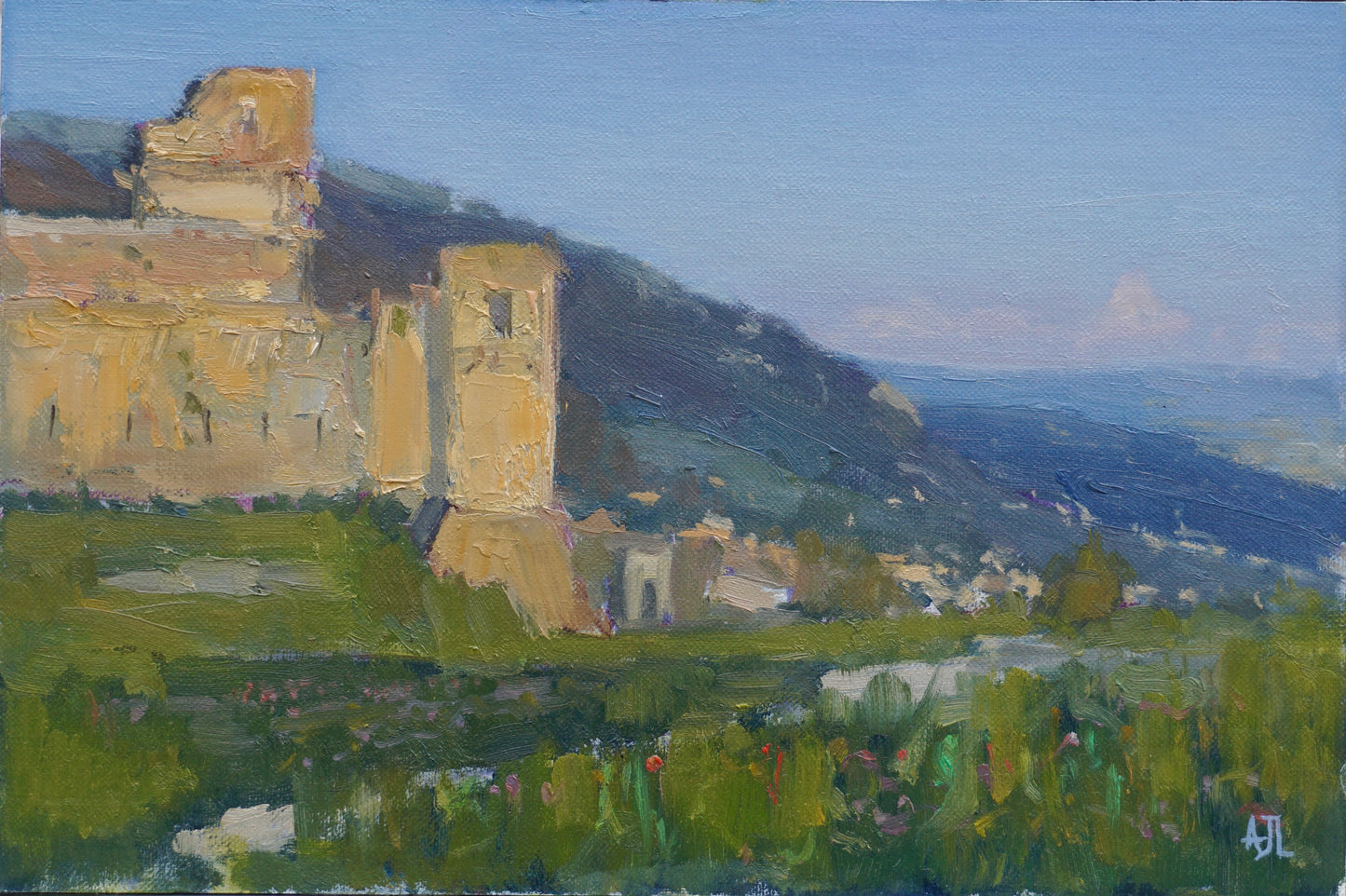 An original oil painting of a sunny day at the top of the hill above the town of Assisi, Italy, with the Rocca Maggiore structure visible in the distance and a lawn with blooming flowers in the foreground. The artist has signed AJL in blue, for "Alex James Long", at the bottom right of the artwork.