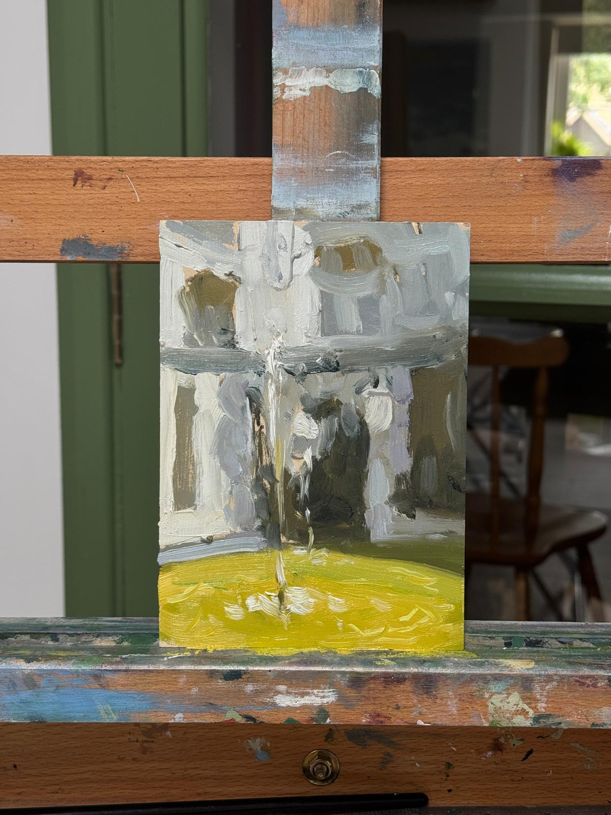 The unsigned painting on a easel in the artist's studio.