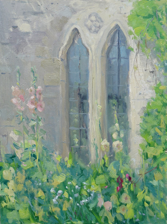 An original oil painting of the Cogges Manor Farm exterior kitchen windows, ancient and double-arched stone, with blooming pastel hollyhocks besides them.