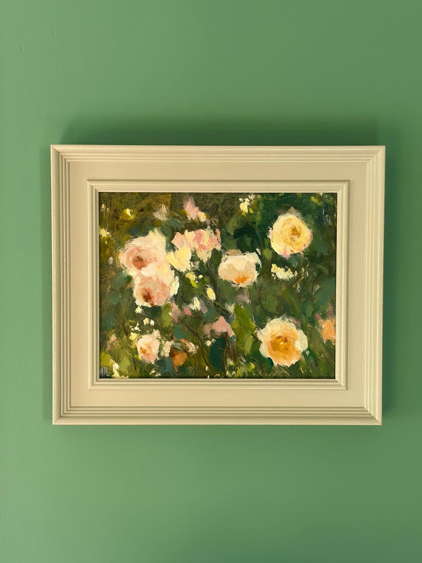 Framed painting of flowers on a green wall