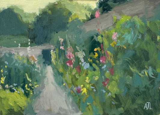 An original oil painting of the walled garden at Cogges Manor Farm, with colourful hollyhocks surrounding both sides of a path in the middle of the painting. The artist has signed AJL in blue, for "Alex James Long", at the bottom right of the artwork.