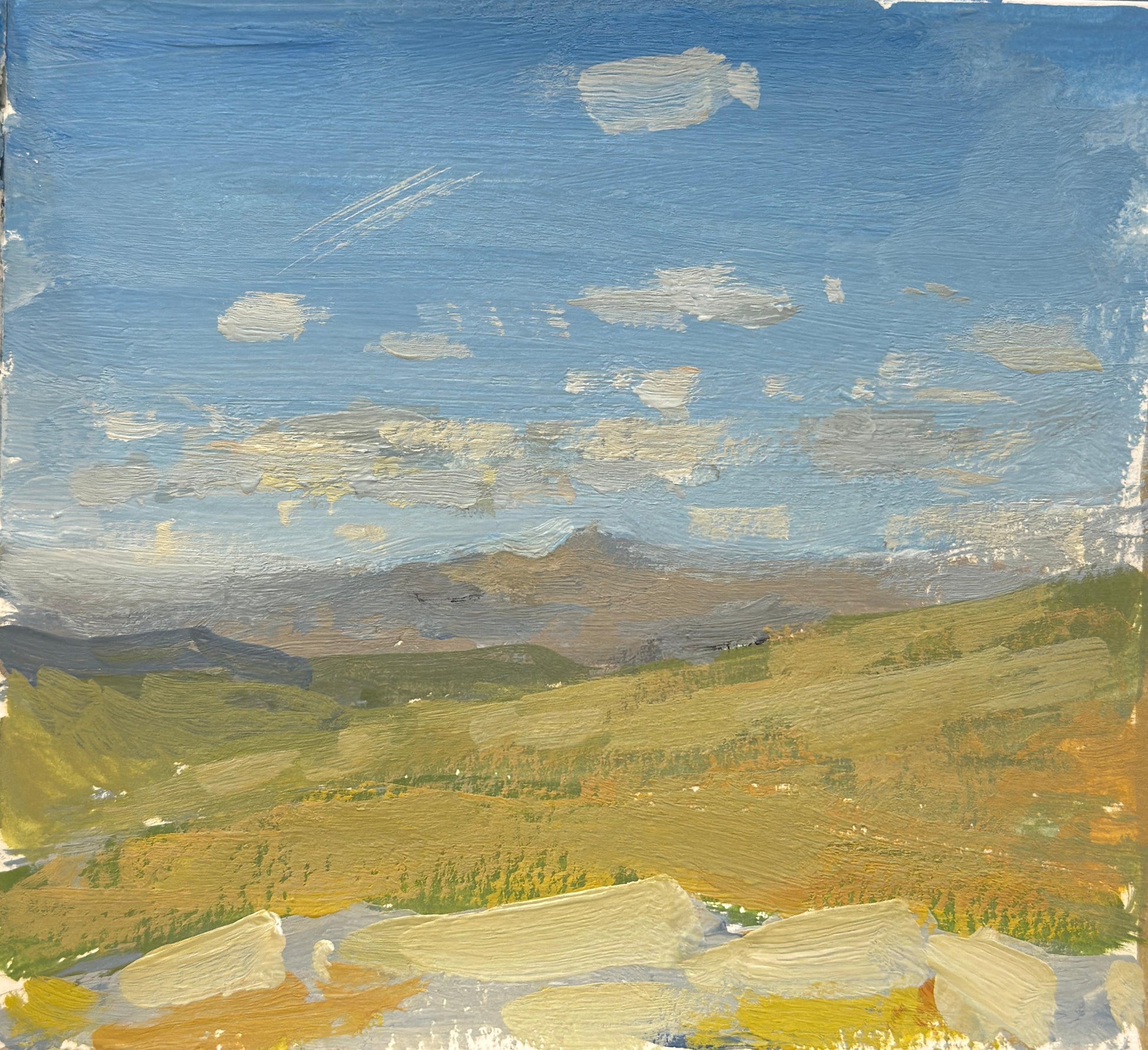 An original gouache painting in an impressionistic manner of clouds in a blue sky over a distant mountain range in the Lake District.
