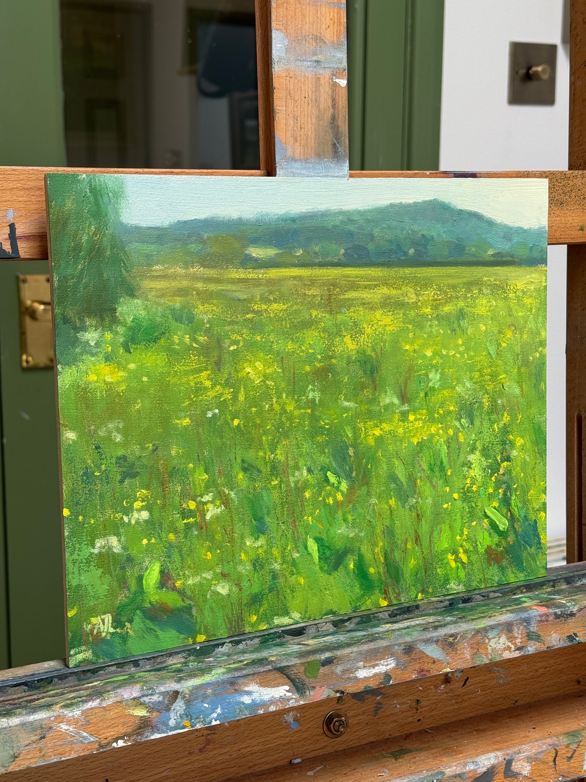 The oil painting photographed from the side as it sits on the artist easel.