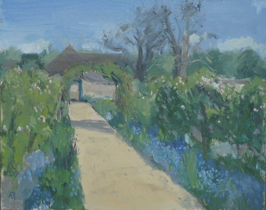 An original oil painting of the walled garden at Cogges Manor Farm in the spring, focusing on a path that is lined by blue forget me nots and pinkish white apple blossoms. The artist has signed AJL in blue, for "Alex James Long", at the bottom left of the artwork. 