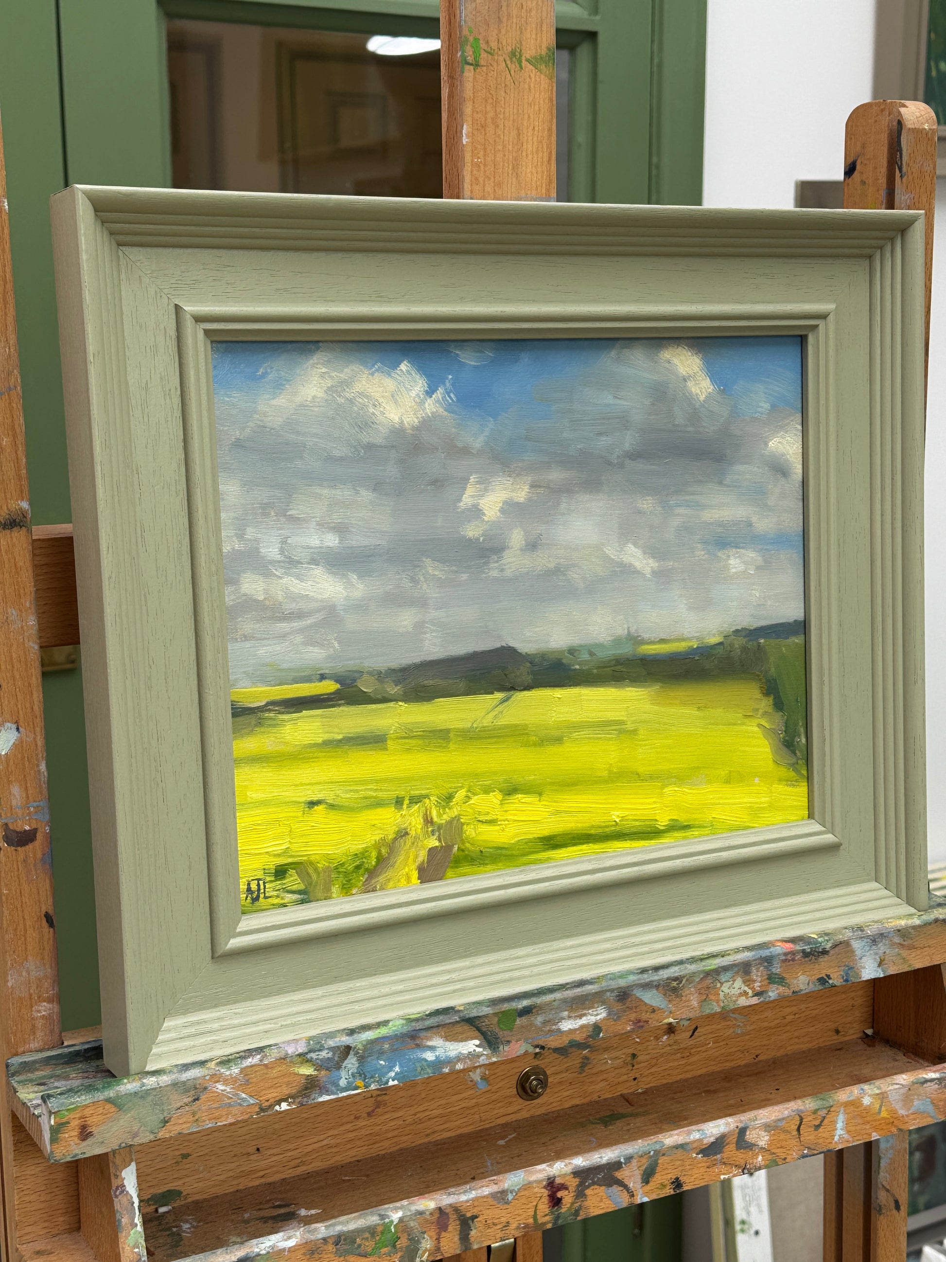The artwork in a wooden frame as photographed from the side.