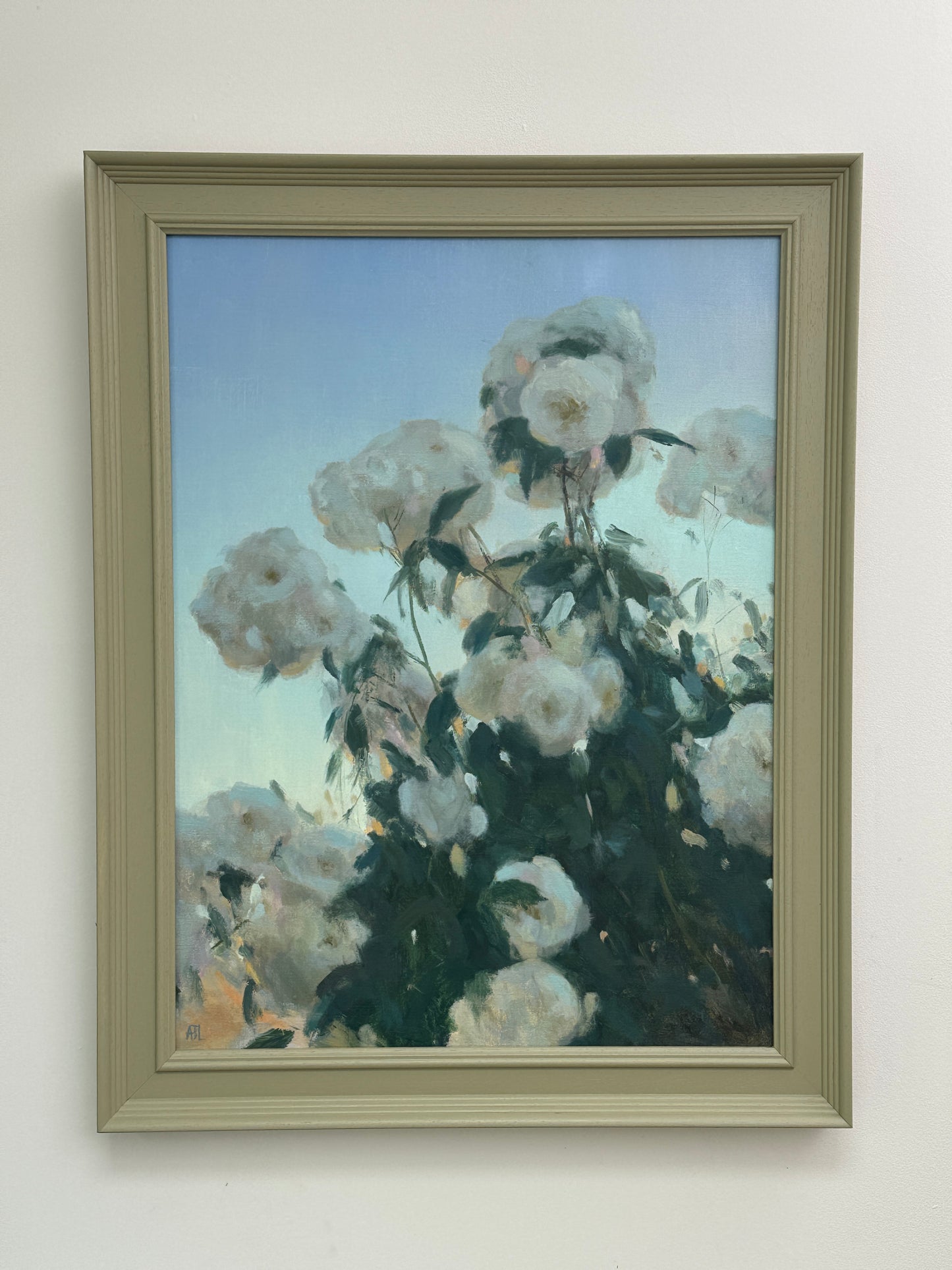 The framed artwork hung on a white wall.