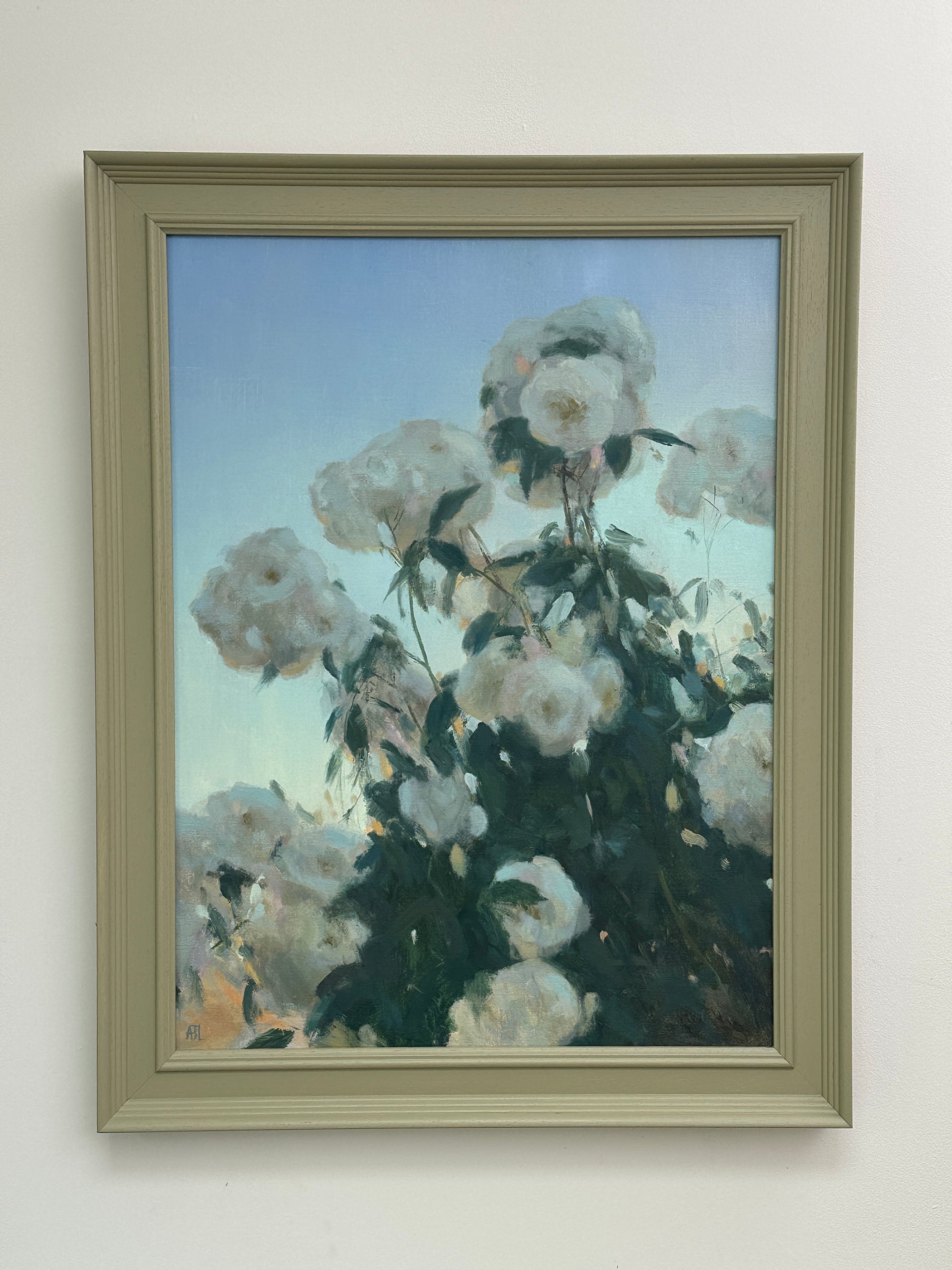 The framed artwork hung on a white wall.