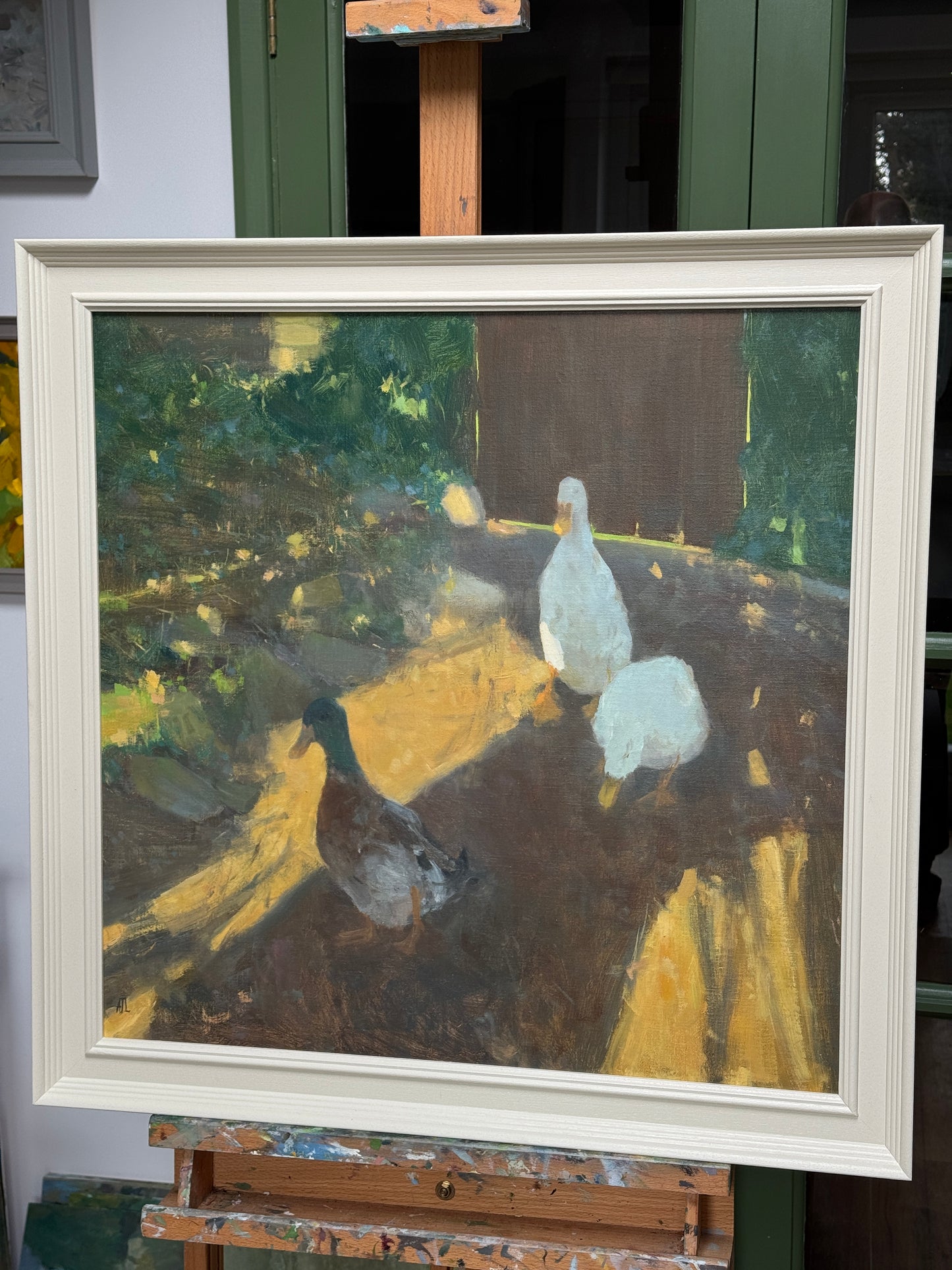The framed painting on the artist easel.