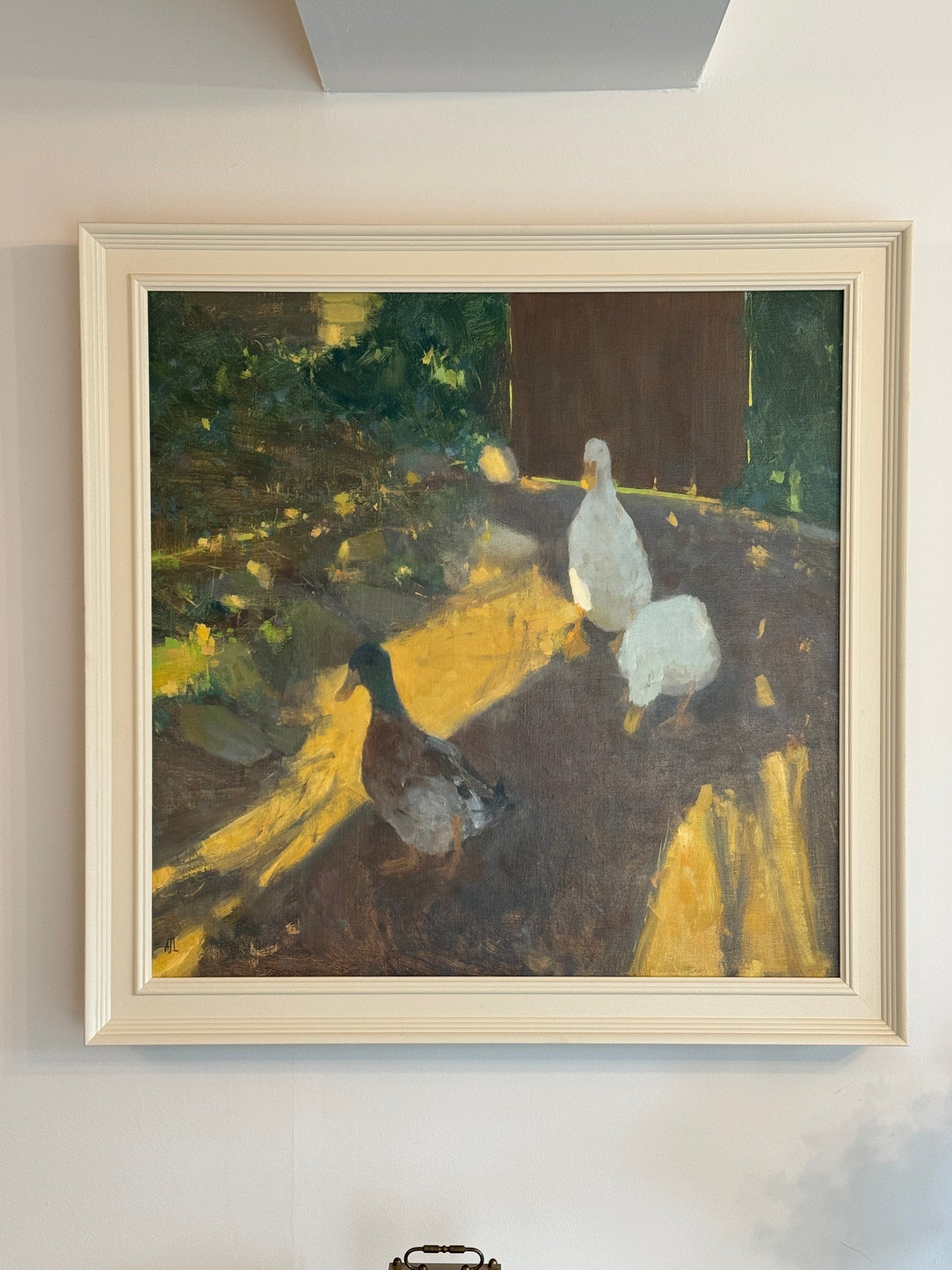 The framed painting hung on a wall.