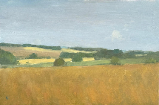 An oil landscape painting depicting a golden wheat field under a pale blue sky, with green trees and rolling hills in the background.