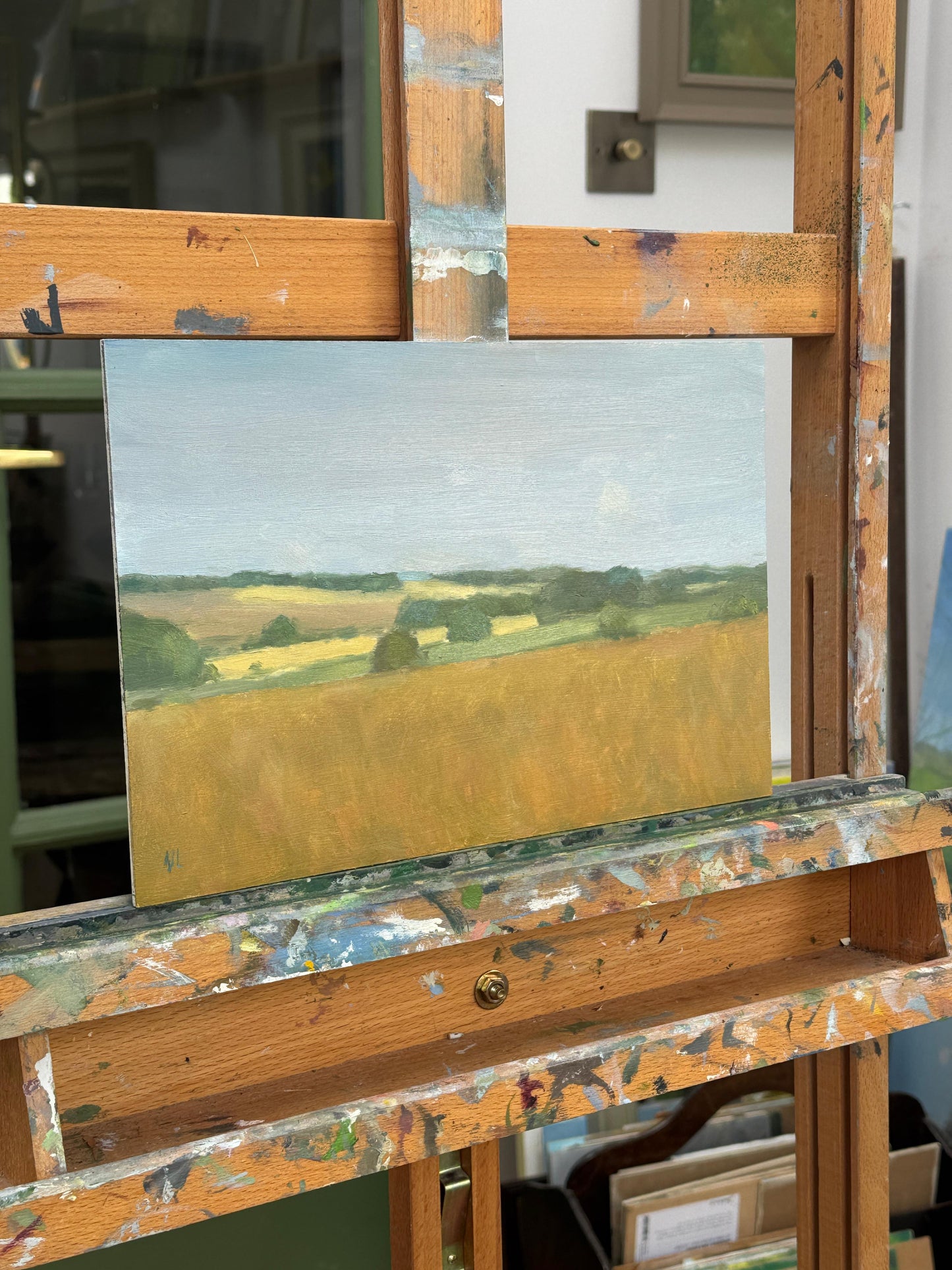 The original oil painting displayed on an artist easel, photographed from the side.