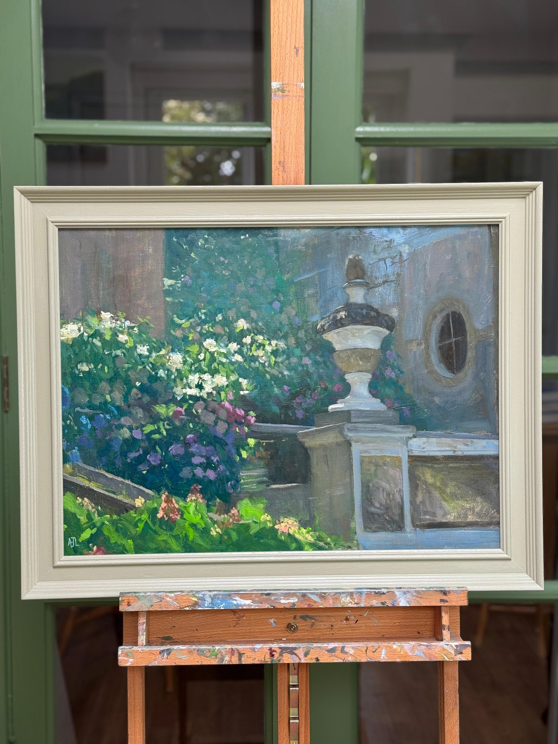 The framed painting on an easel.