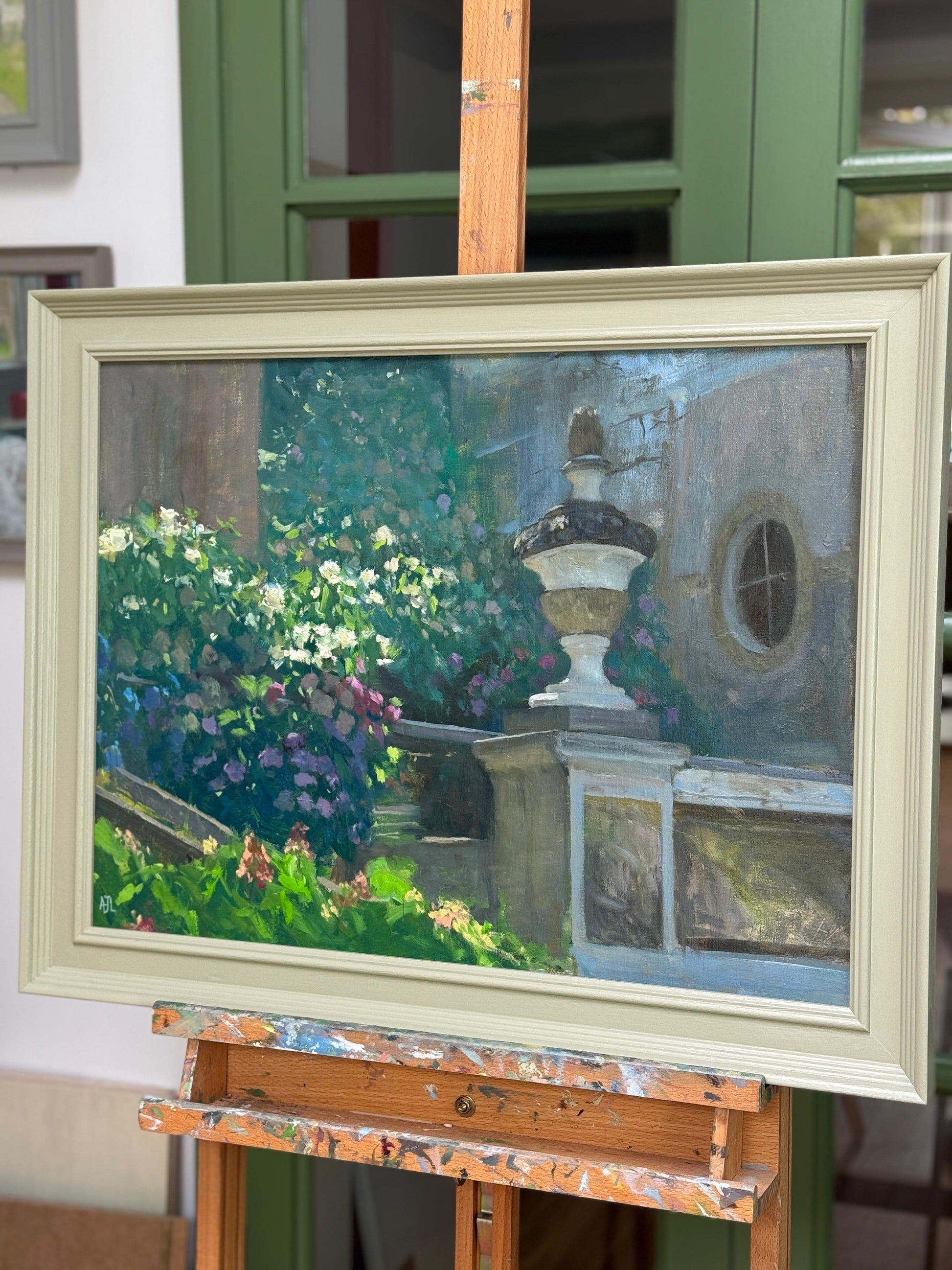 The framed painting on an easel seen from the side.