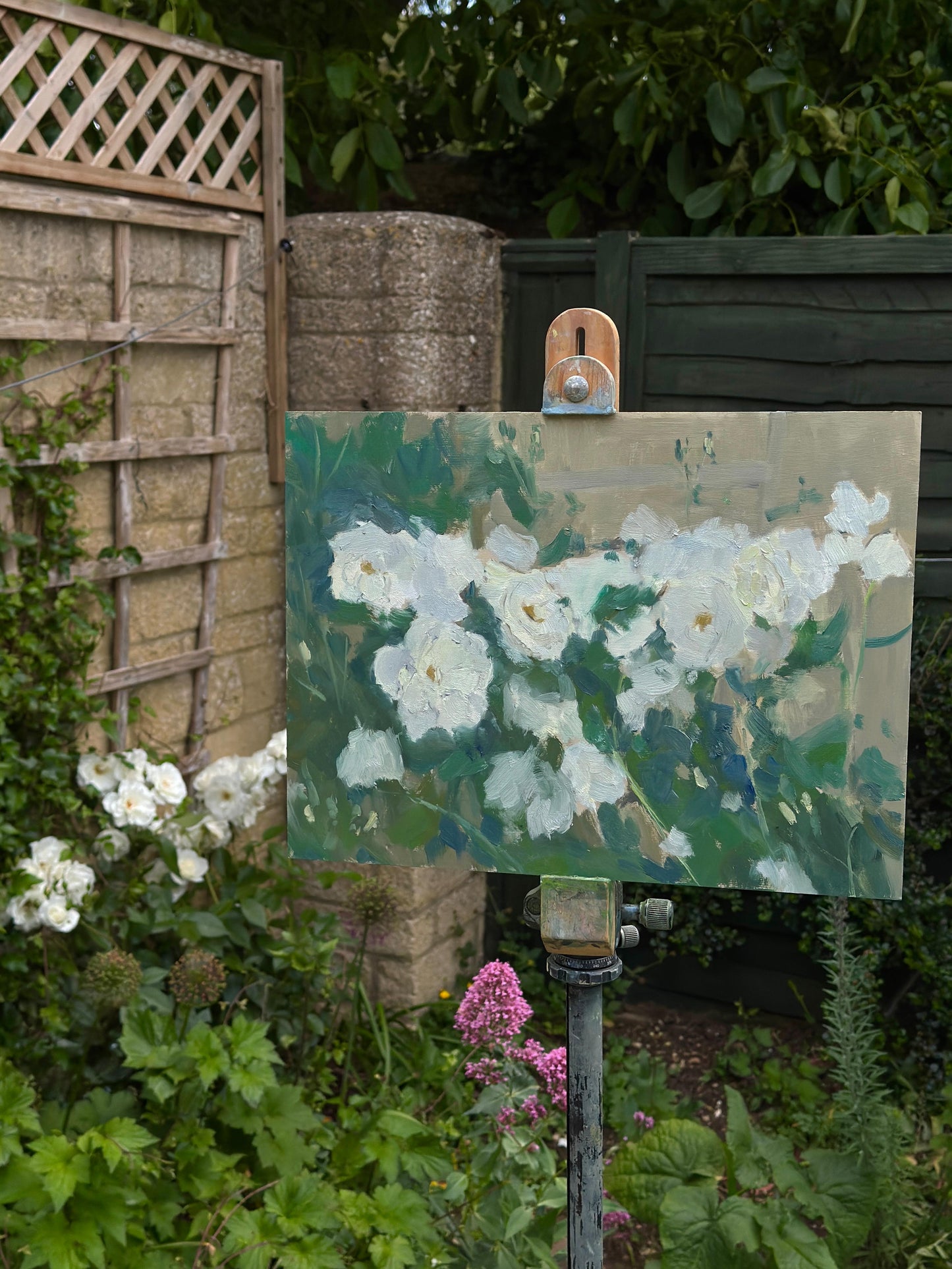 The original artwork on an easel with the depicted white roses visible to the left.