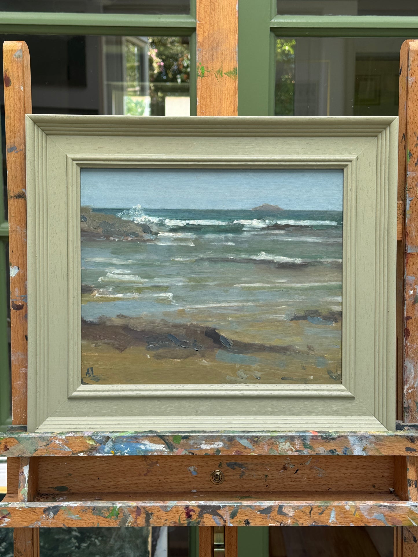 The framed artwork sitting on the artist easel.