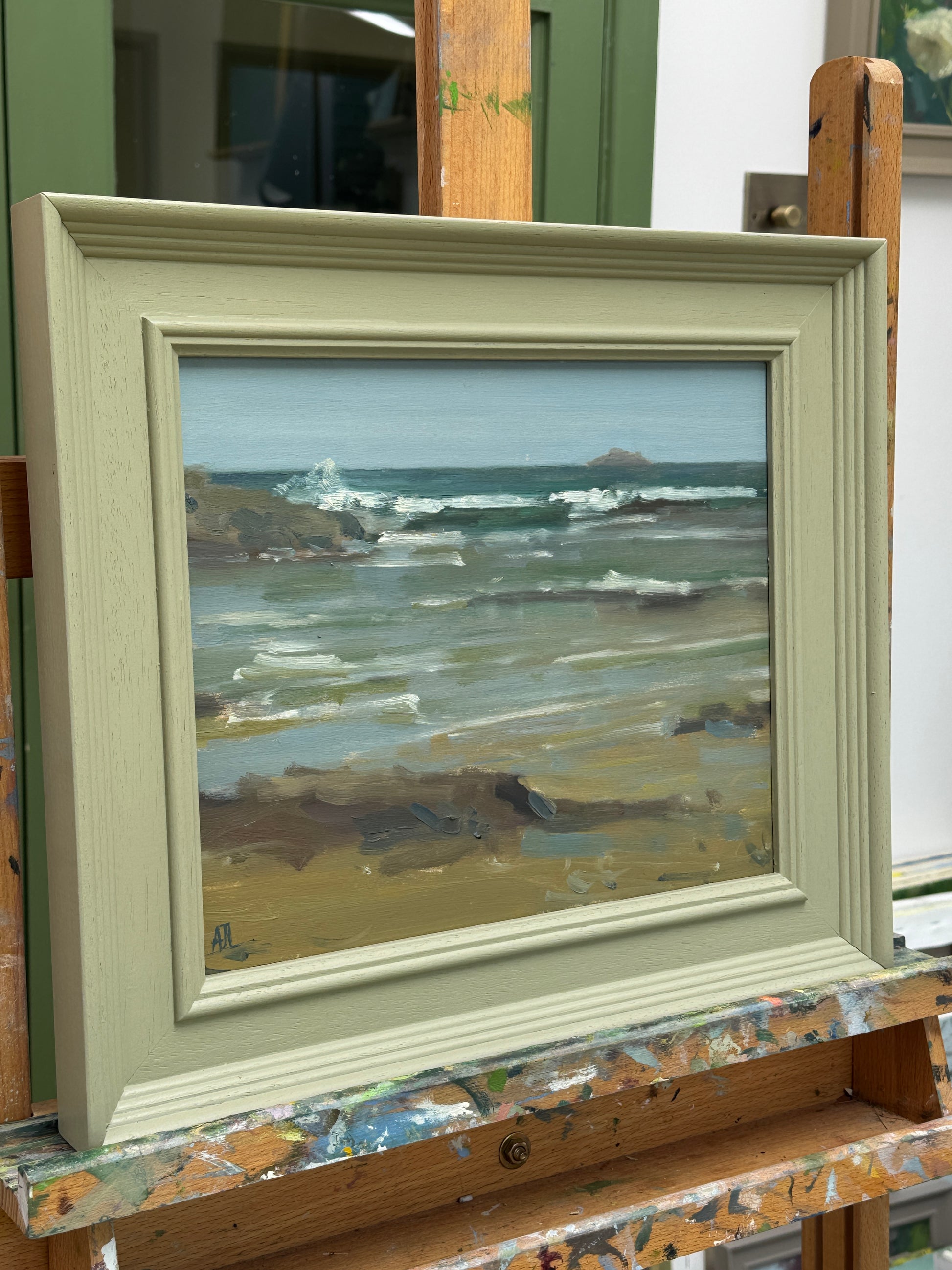 A side view of the painting in a green-painted wooden frame.
