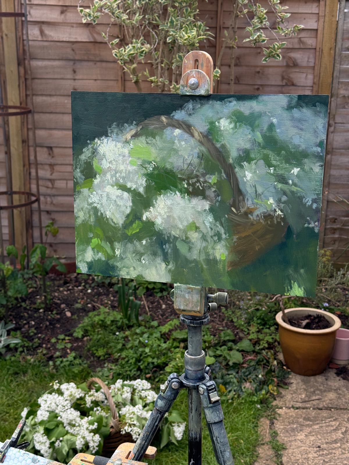 The painting outside by the basket of lilacs.
