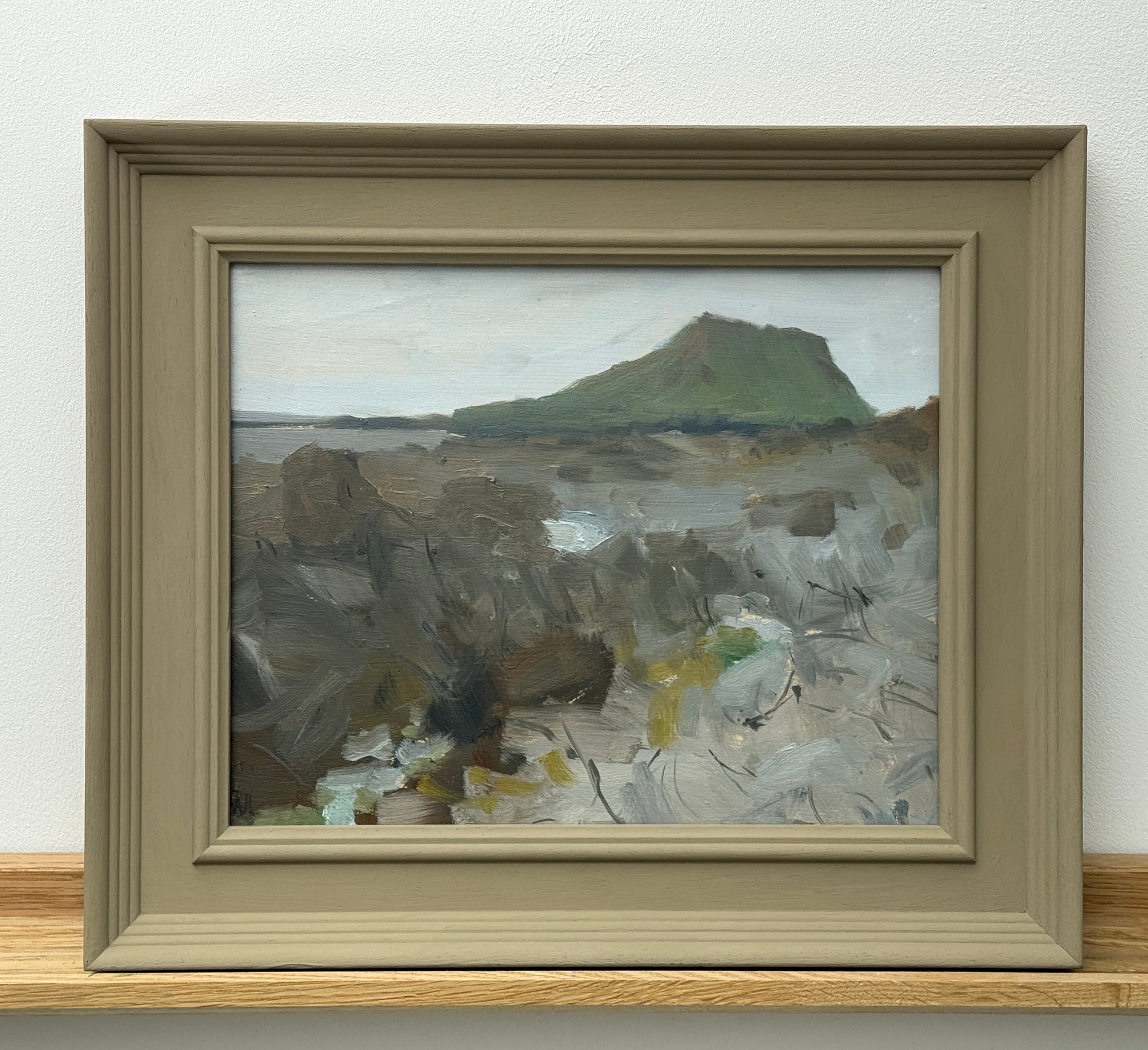 The painting in a painted wooden frame.