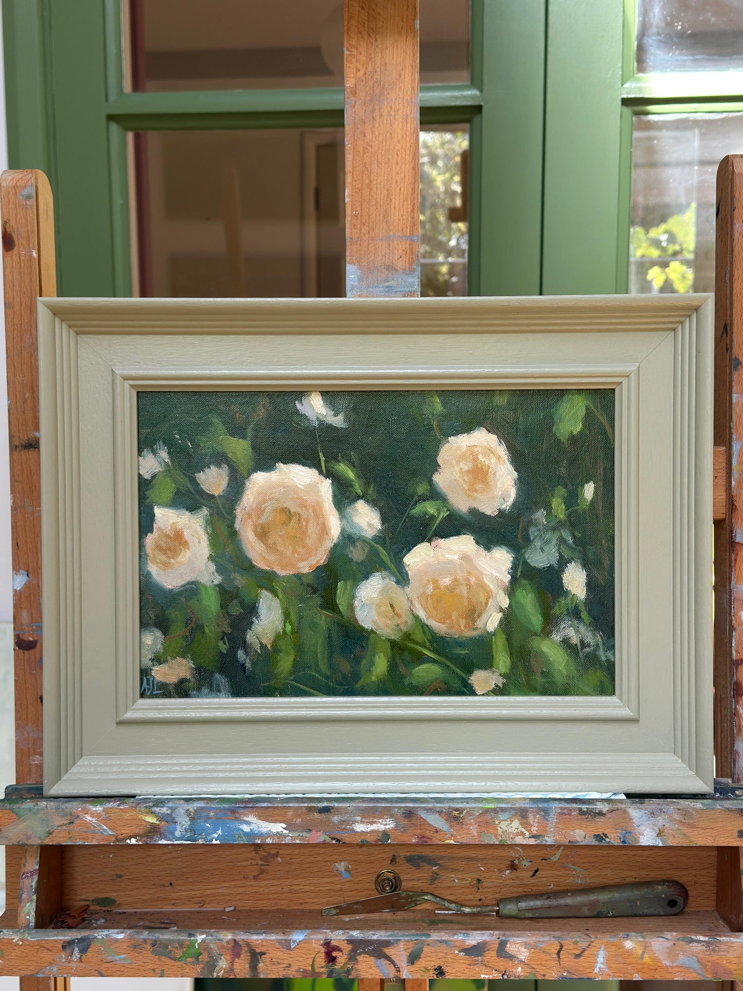 Framed painting of roses on a wooden easel