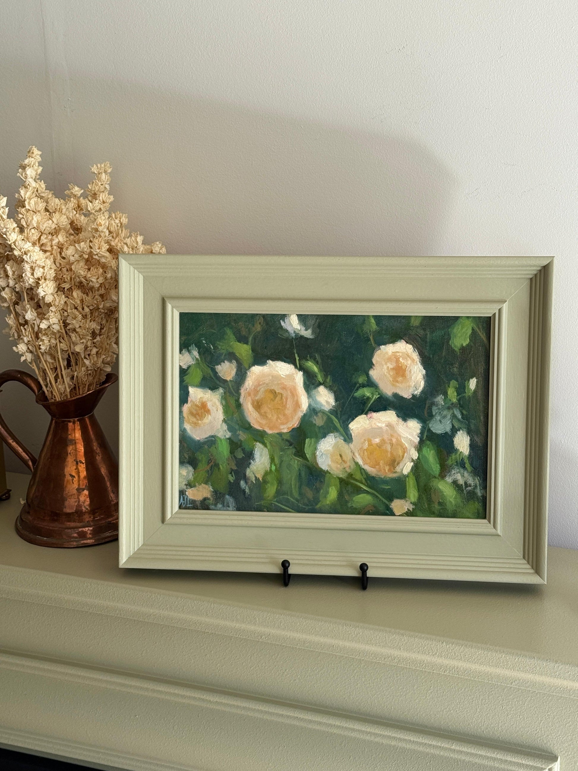Framed painting of flowers on a shelf with a vase of dried flowers.