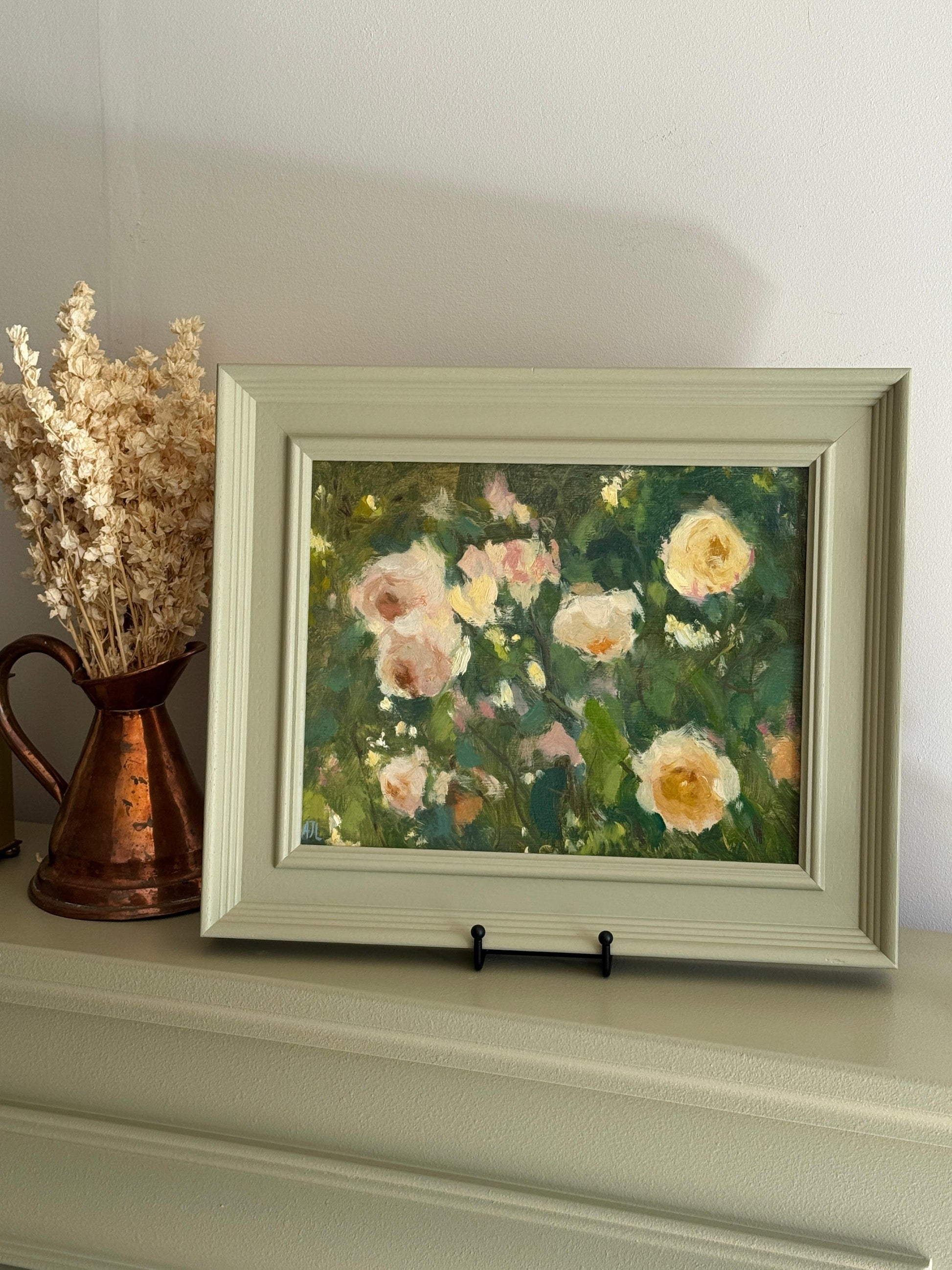 Framed painting of flowers on a shelf with a copper pitcher and dried plants.