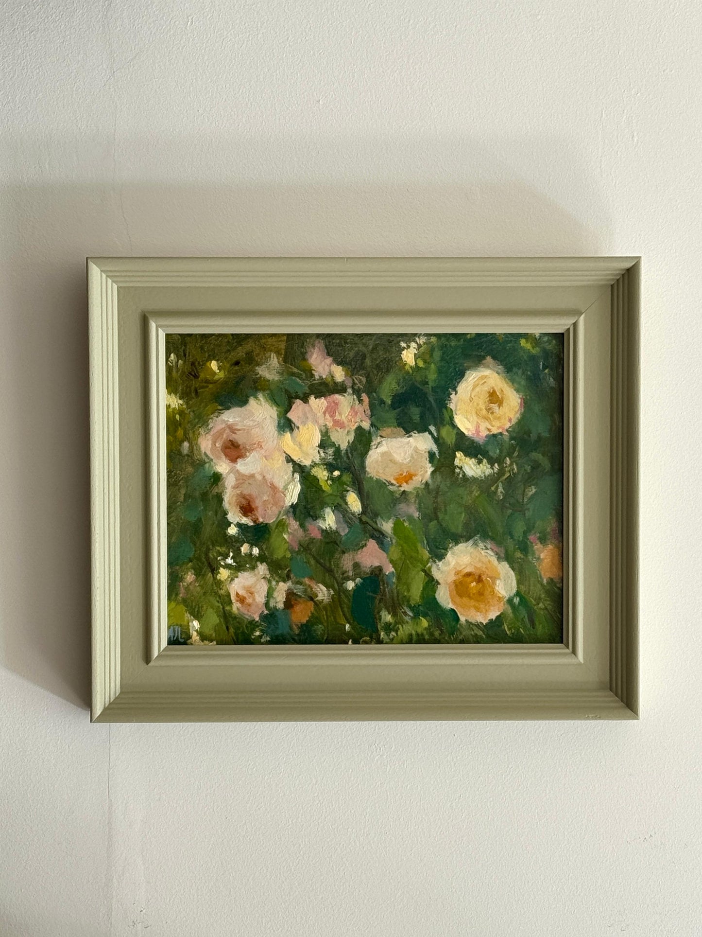 Framed painting of flowers on a white wall