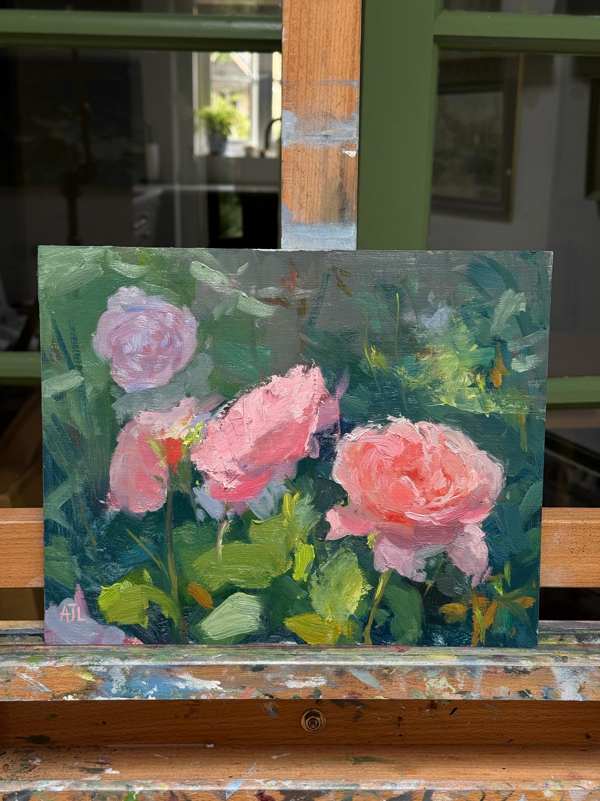 Painting of pink roses on a wooden easel