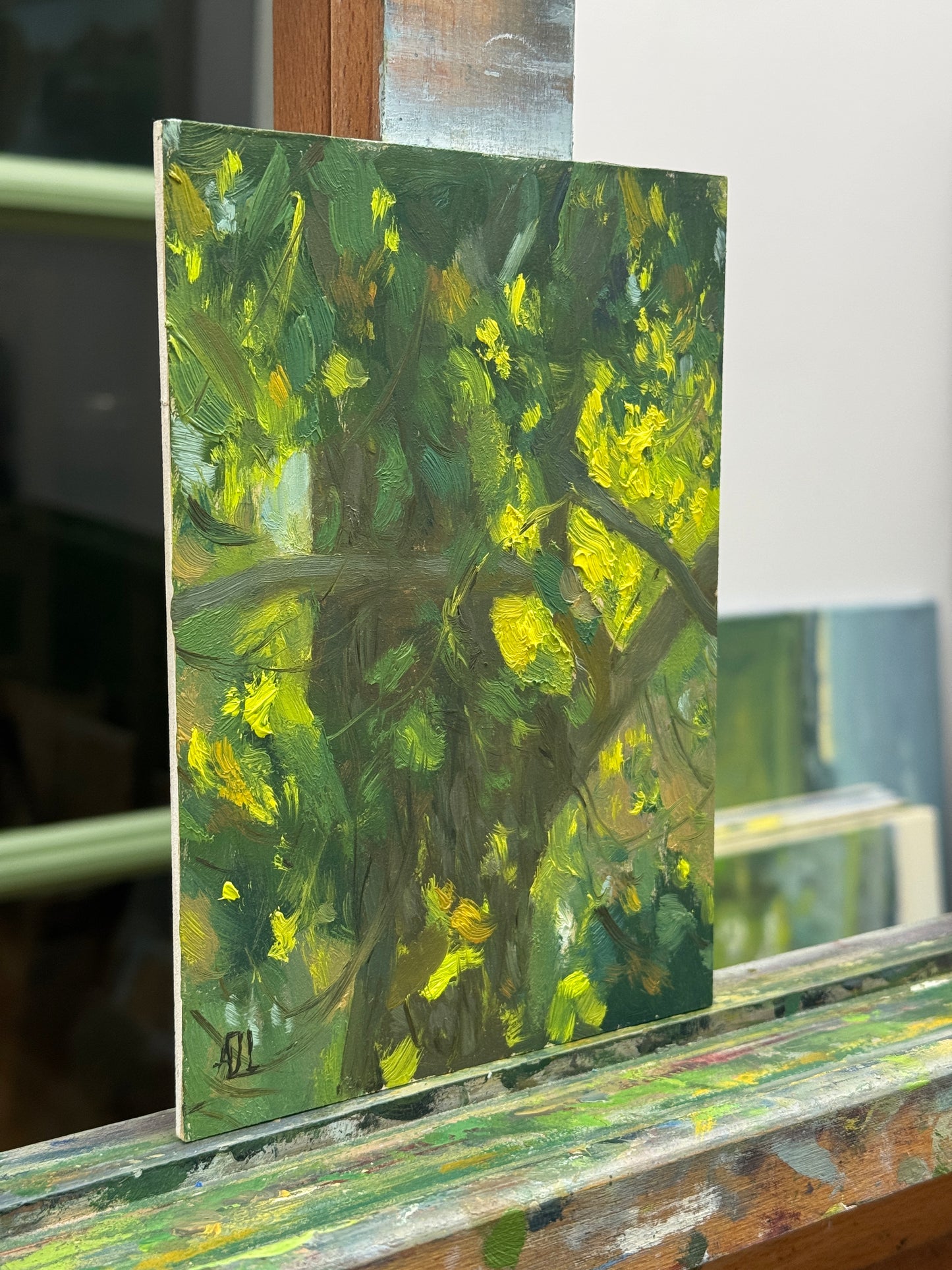 The original oil painting on the artist easel seen from the side.