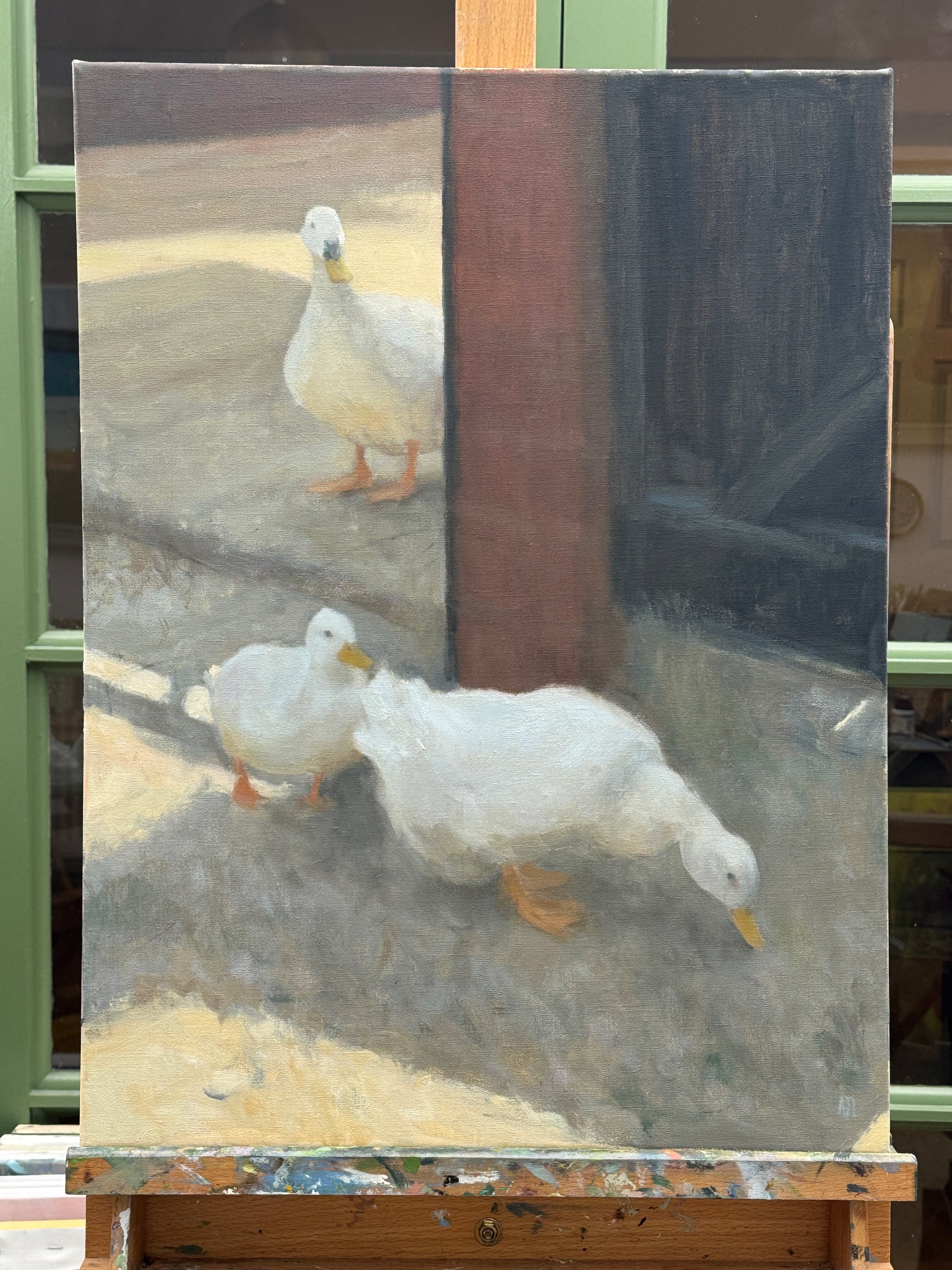 An oil painting on canvas depicting three white ducks in a courtyard, displayed on an artist's easel. The painting features two white ducks in the foreground and another in the background, with a dark brown pillar and a gray ground.