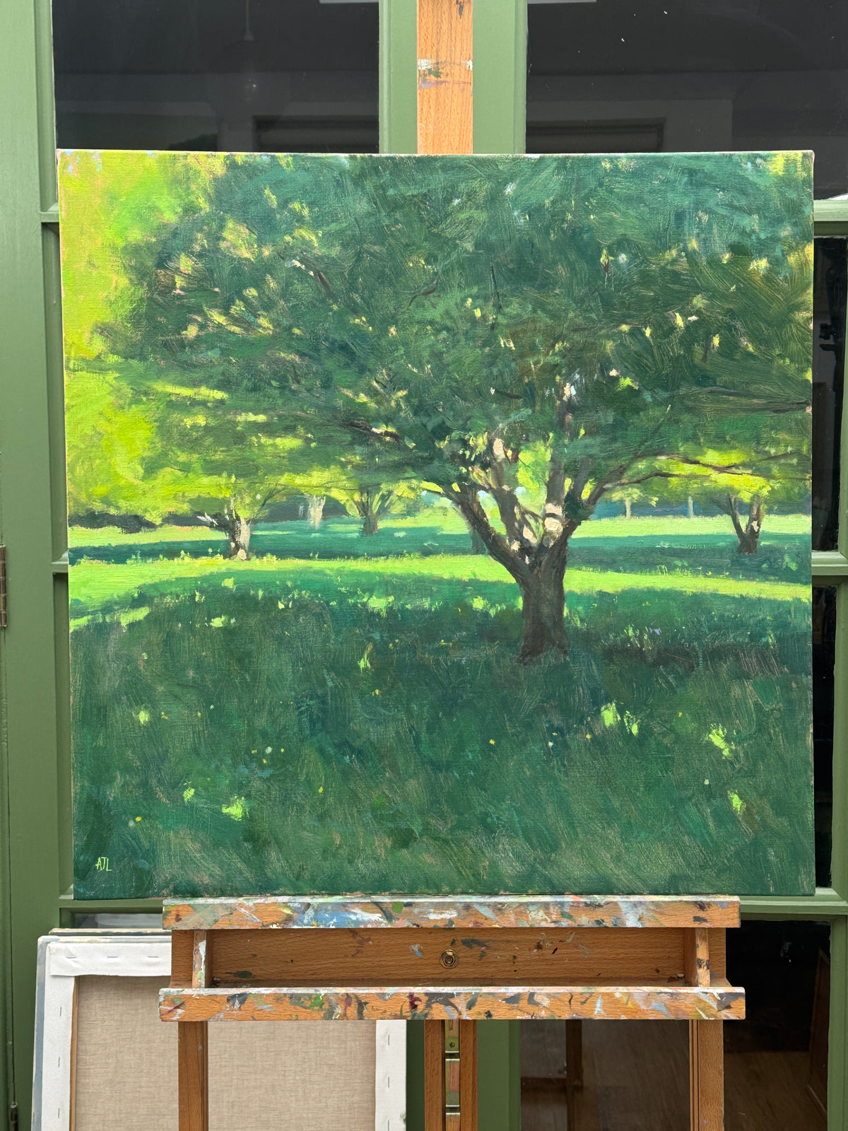 The unframed oil painting on an easel.