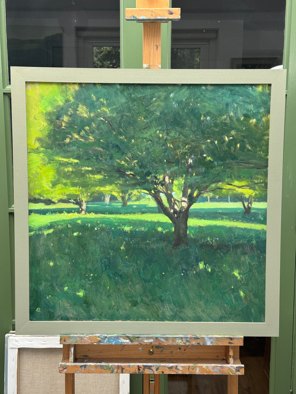 The framed painting on the artist's easel.
