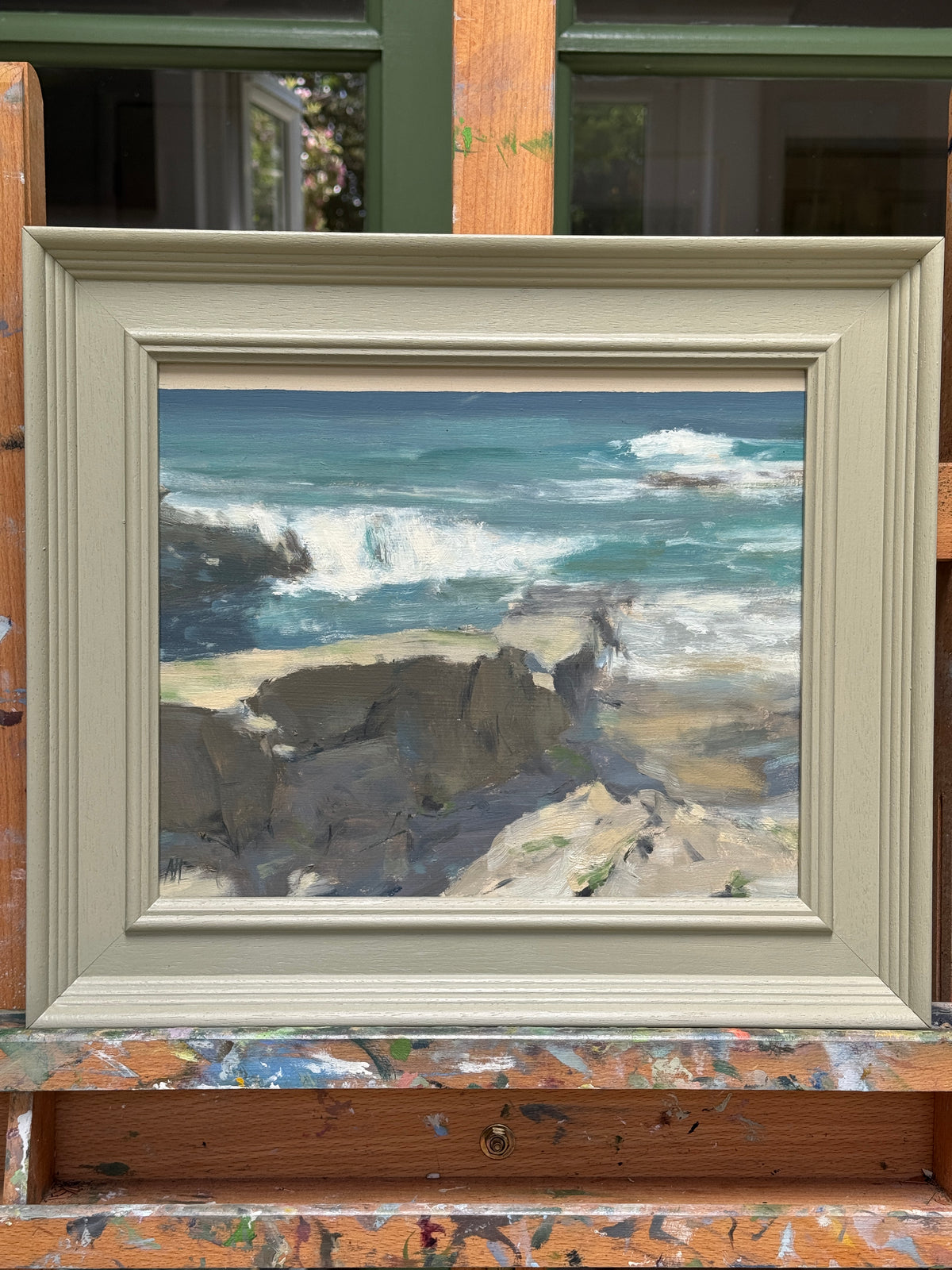 The artwork presented in a painted wooden frame.