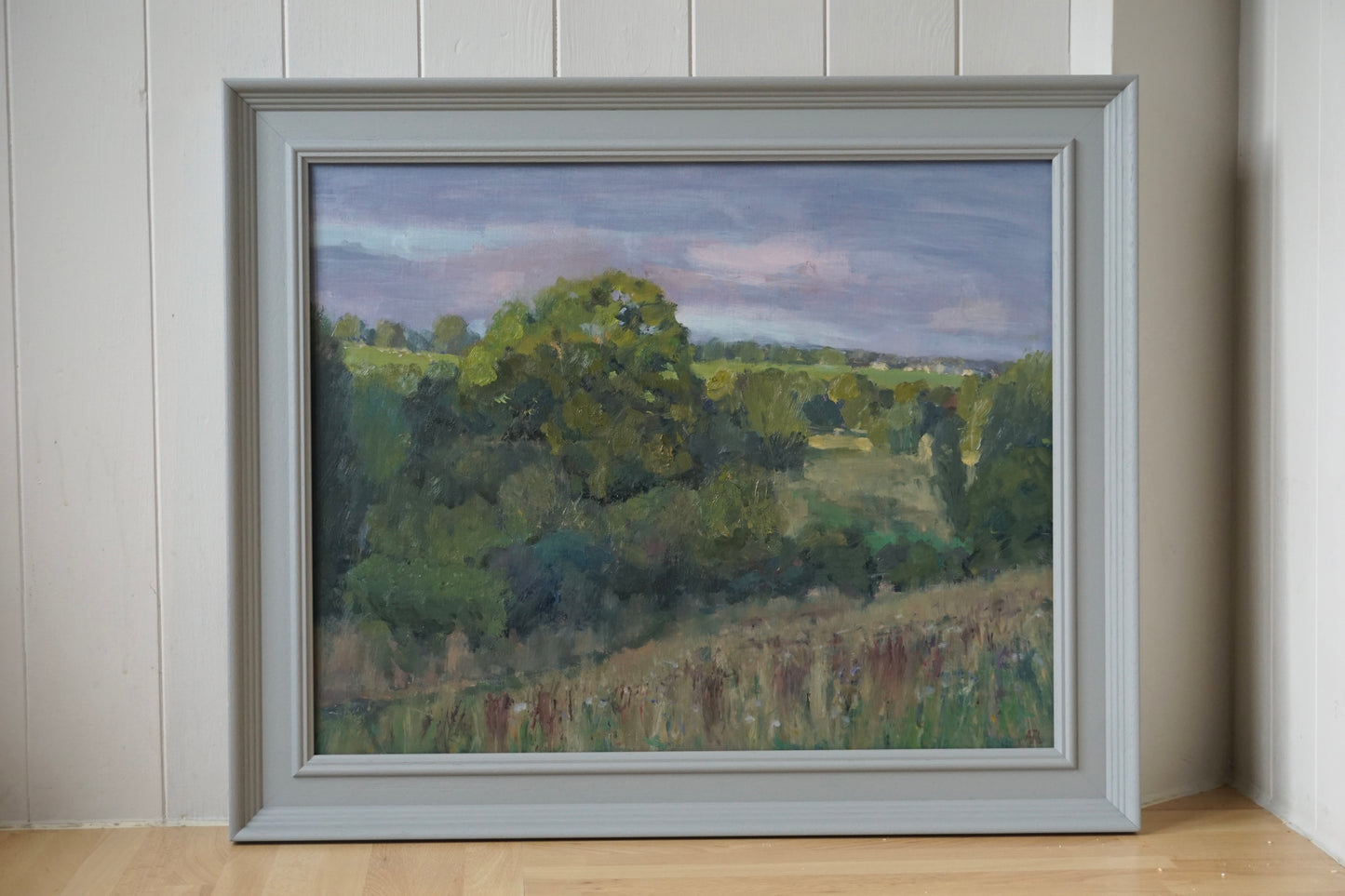 An original oil painting of a Windrush Valley field in a grey frame. 