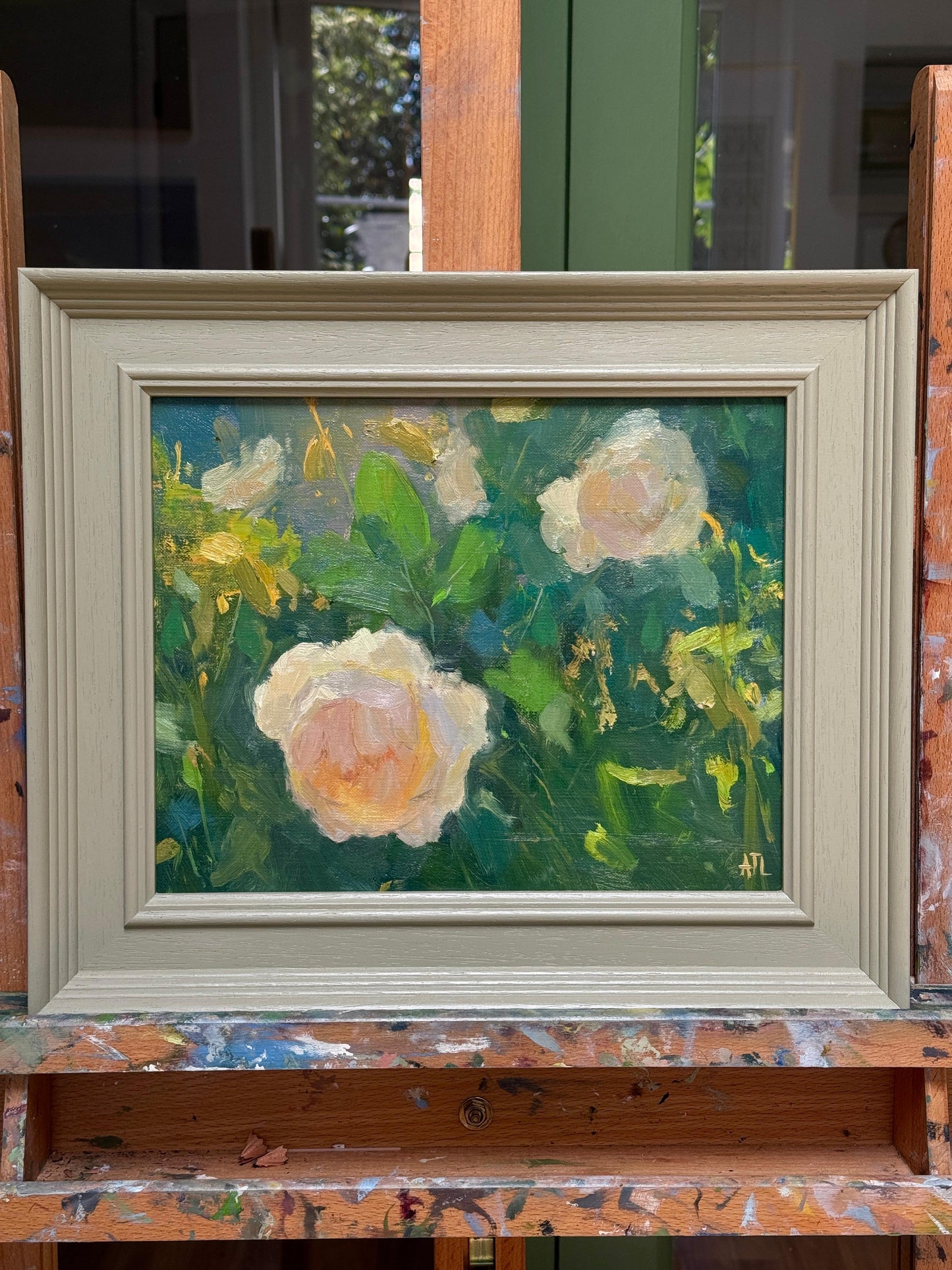 Framed painting of flowers on a wooden easel.