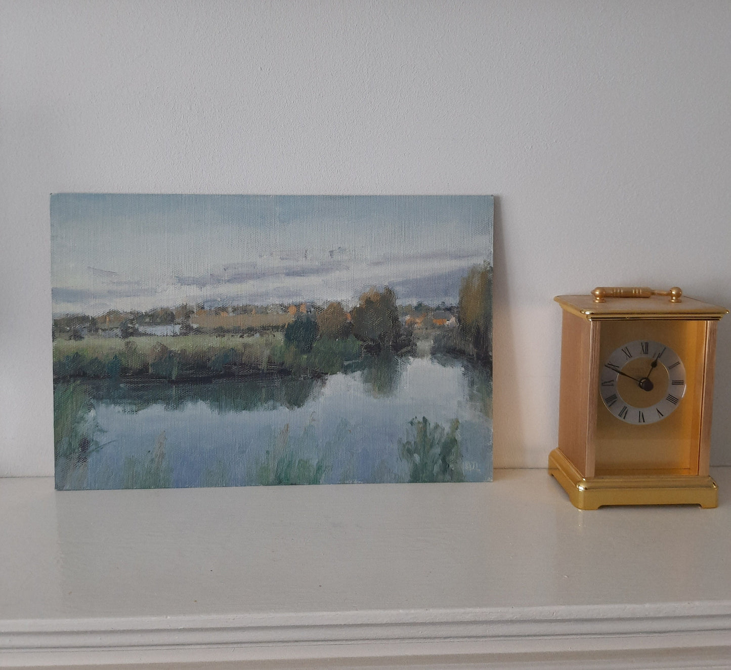 The unframed painting sat on the mantelpiece